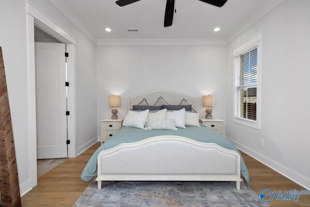 bedroom with crown molding, light hardwood / wood-style flooring, and ceiling fan