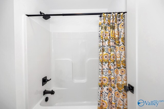 bathroom with shower / bath combo with shower curtain