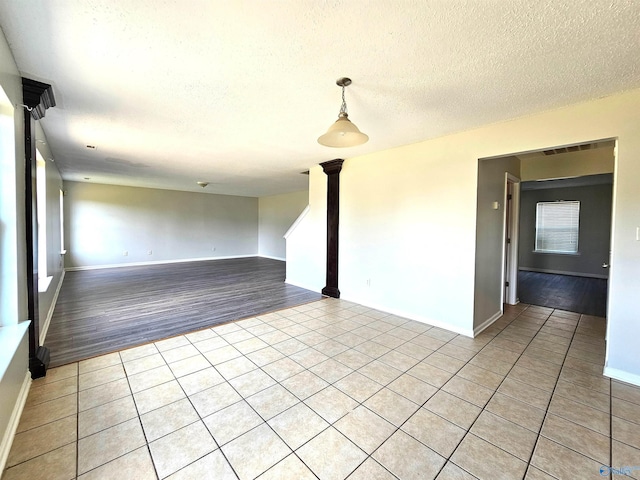 unfurnished room featuring light tile patterned flooring and a textured ceiling