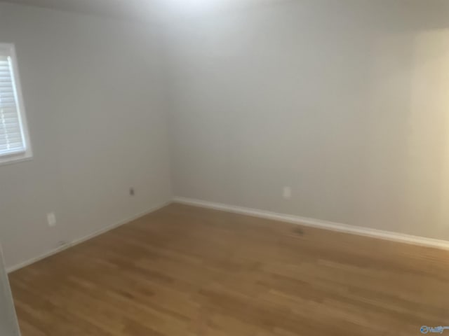 empty room featuring baseboards and light wood-style floors