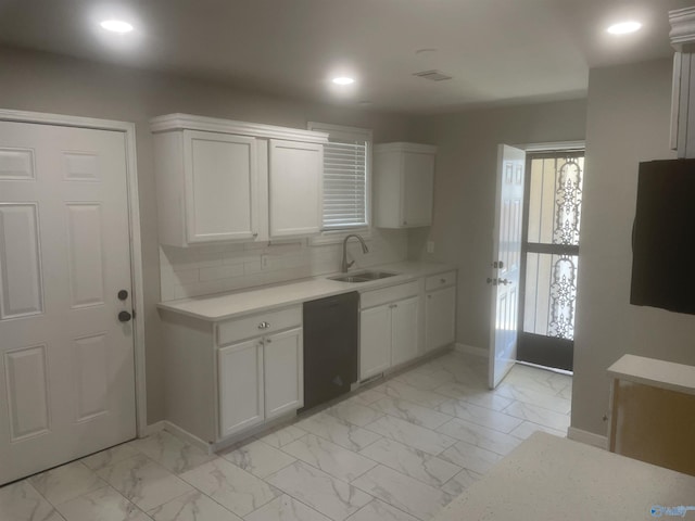 kitchen with marble finish floor, black dishwasher, light countertops, and a sink