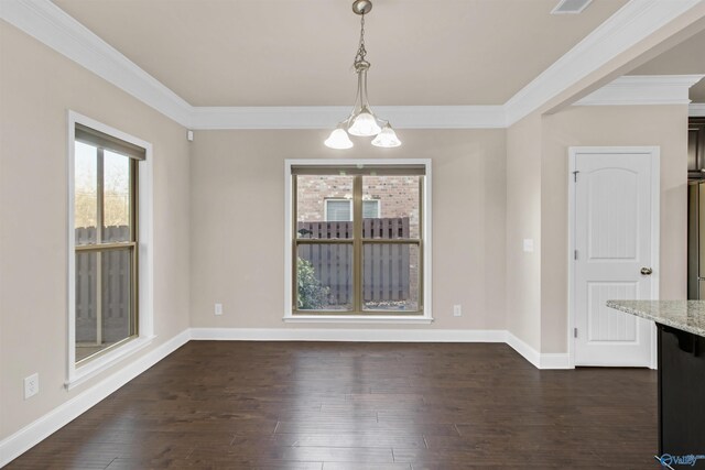 unfurnished dining area featuring dark wood finished floors, crown molding, baseboards, and a chandelier