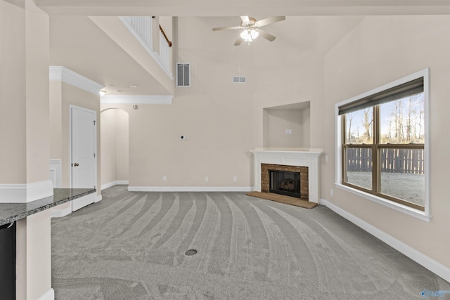 unfurnished living room featuring visible vents, baseboards, carpet, and a high ceiling