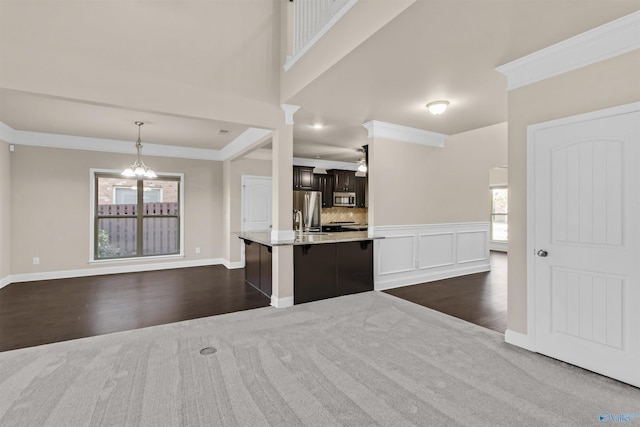 kitchen with open floor plan, a healthy amount of sunlight, appliances with stainless steel finishes, and ornamental molding