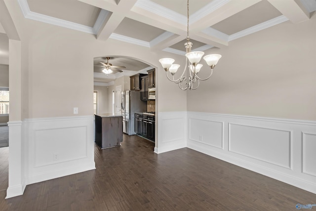 unfurnished dining area with ceiling fan with notable chandelier, beamed ceiling, dark wood-style floors, and arched walkways