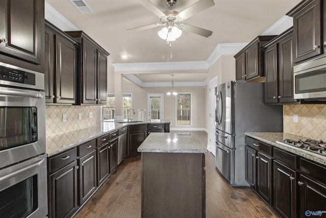 kitchen with visible vents, ornamental molding, appliances with stainless steel finishes, dark wood-style floors, and a sink