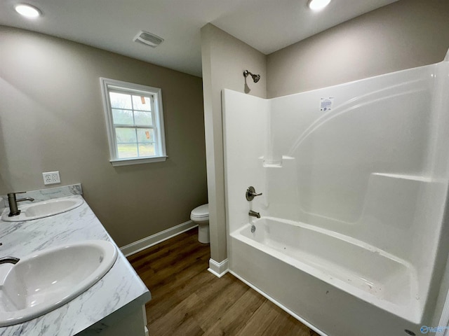 full bathroom with bathtub / shower combination, wood-type flooring, vanity, and toilet