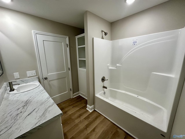 bathroom with hardwood / wood-style floors, vanity, and shower / washtub combination