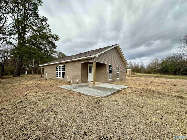 rear view of house featuring a yard and a patio