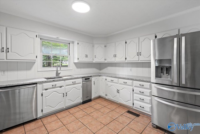 kitchen featuring sink, appliances with stainless steel finishes, light tile patterned floors, and white cabinetry