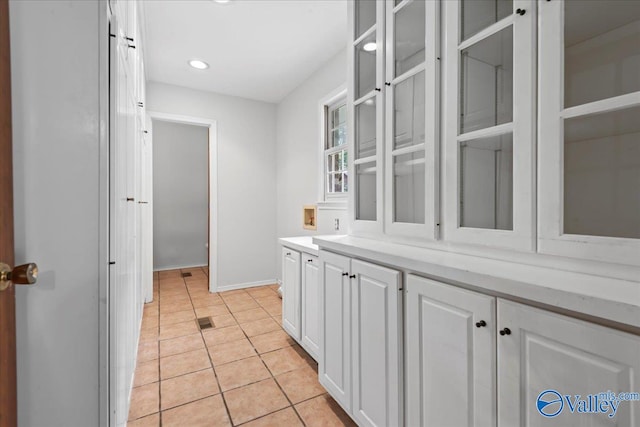 kitchen featuring light tile patterned flooring and white cabinets