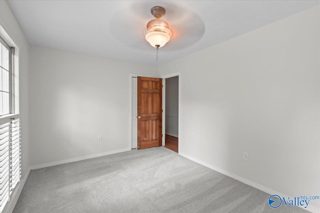 carpeted spare room with ceiling fan