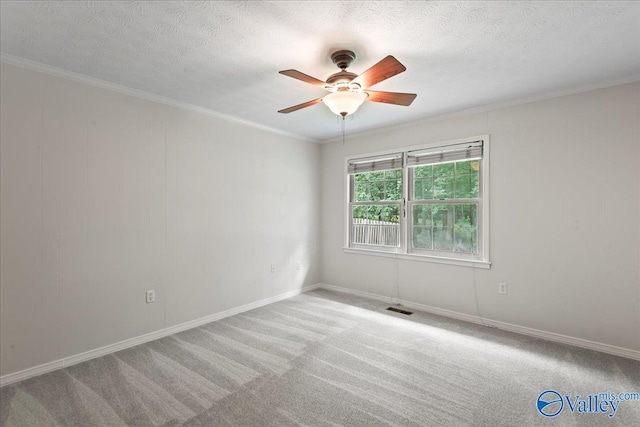 carpeted spare room with crown molding, a textured ceiling, and ceiling fan