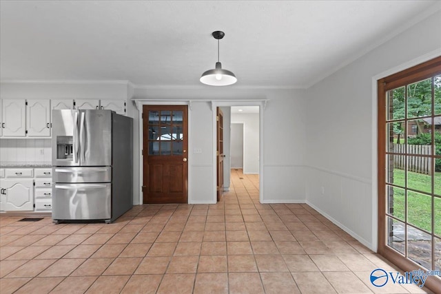 kitchen with white cabinetry, pendant lighting, stainless steel fridge, and light tile patterned floors