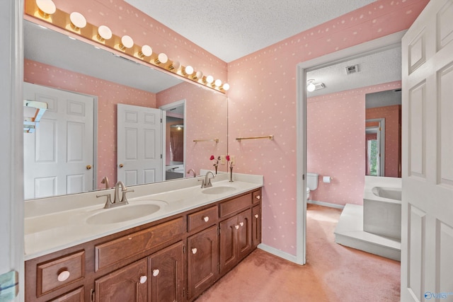 bathroom with a tub to relax in, a textured ceiling, and vanity