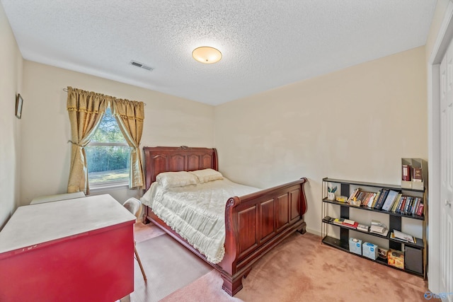 bedroom featuring a textured ceiling and light colored carpet