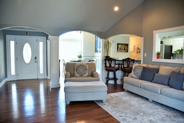 living room with decorative columns, dark wood-type flooring, and high vaulted ceiling