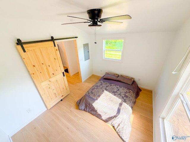 140 Ben Johnson Rd, Pulaski, TN 38478 - bedroom featuring electric panel, light wood-style floors, baseboards, a barn door, and ceiling fan