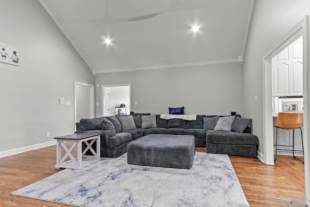 living room featuring crown molding, baseboards, and wood finished floors