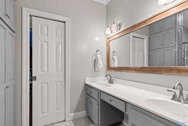 full bathroom featuring tile patterned flooring, a sink, baseboards, and double vanity