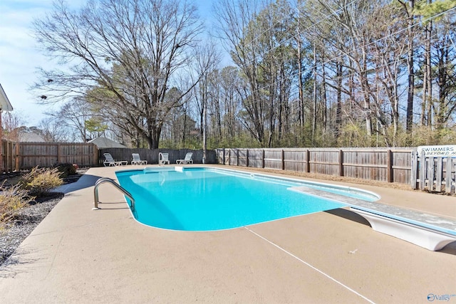 view of swimming pool with a diving board, a patio area, a fenced backyard, and a fenced in pool