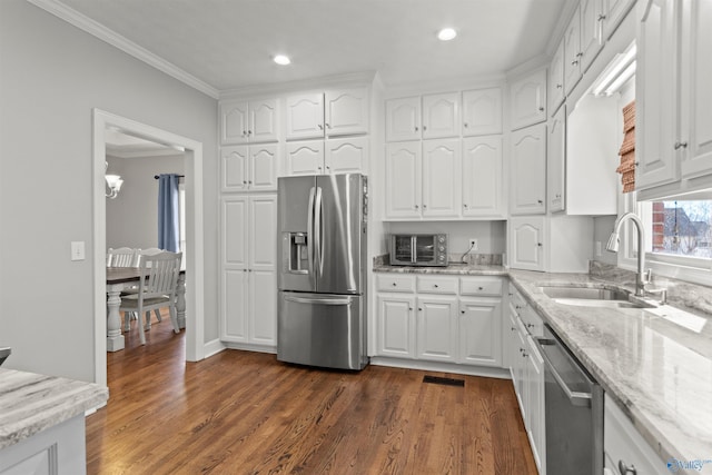 kitchen with appliances with stainless steel finishes, white cabinets, and a sink