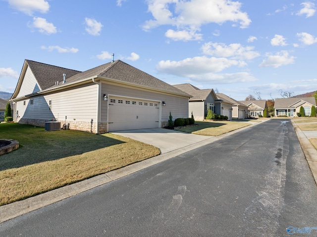 ranch-style home featuring cooling unit and a front lawn