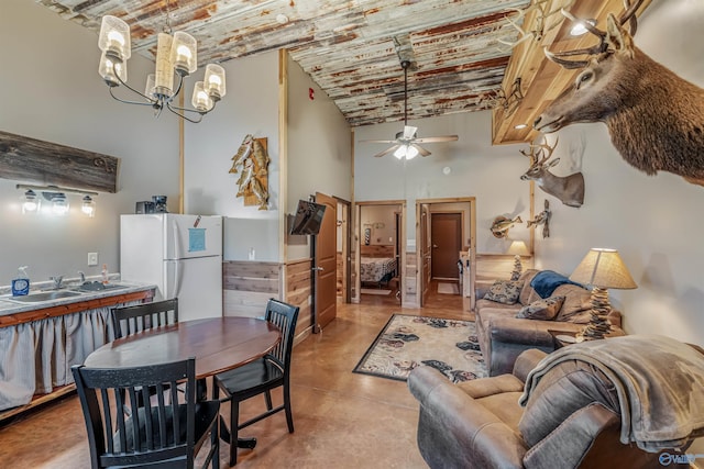 living room featuring brick ceiling, a high ceiling, ceiling fan with notable chandelier, and finished concrete flooring