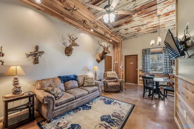 living room featuring concrete floors and ceiling fan with notable chandelier