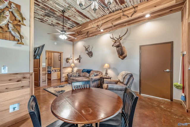 dining space with brick ceiling, concrete floors, a towering ceiling, and ceiling fan