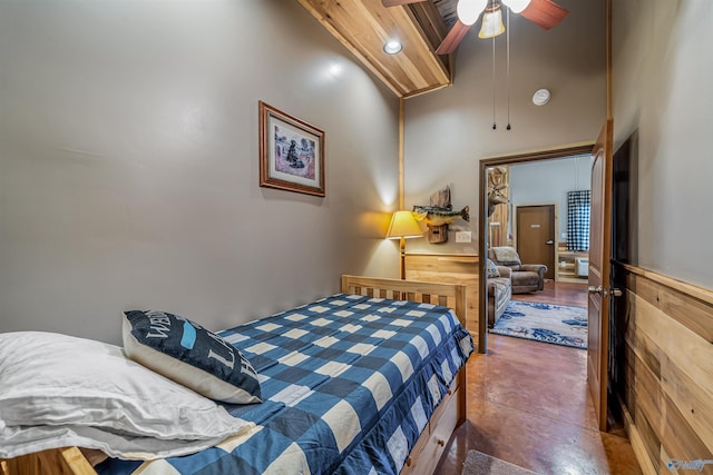 bedroom with high vaulted ceiling, beamed ceiling, finished concrete flooring, and ceiling fan