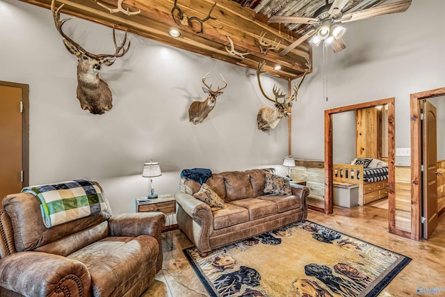 living room featuring ceiling fan and a high ceiling