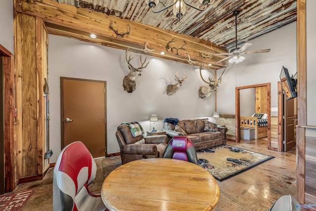 living room featuring a towering ceiling, a ceiling fan, and beamed ceiling