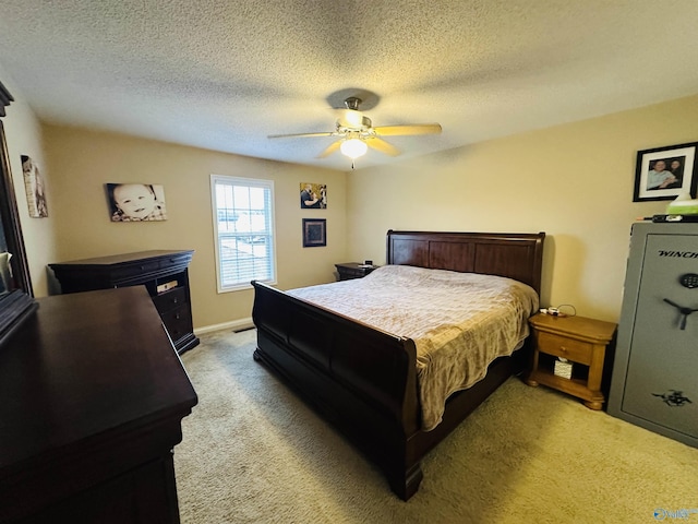 carpeted bedroom featuring ceiling fan and a textured ceiling