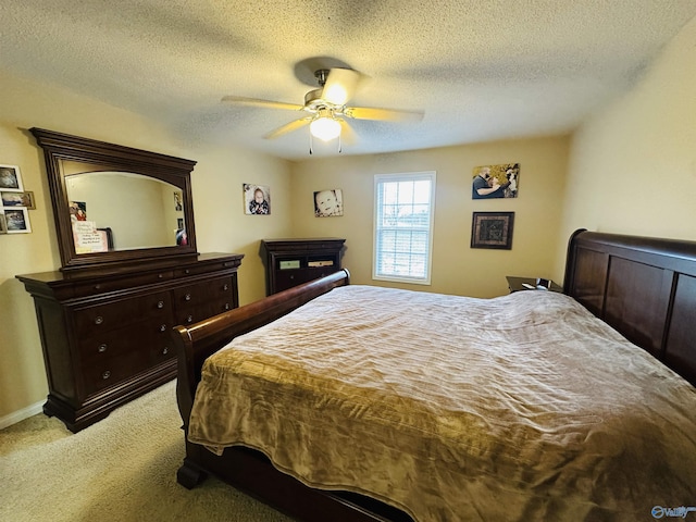 bedroom with ceiling fan, a textured ceiling, and light carpet