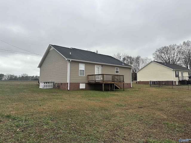 rear view of property featuring a lawn and a deck