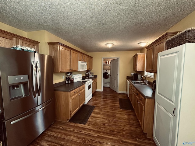 kitchen featuring white appliances, dark wood-type flooring, sink, a textured ceiling, and washer / dryer