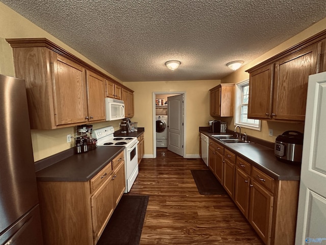 kitchen with a textured ceiling, white appliances, sink, washer / clothes dryer, and dark hardwood / wood-style floors