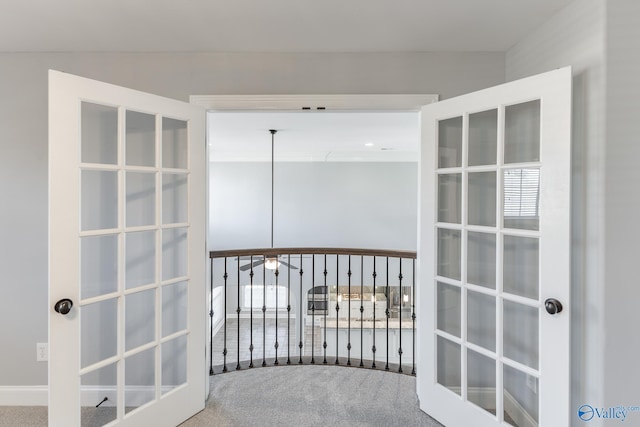 hallway featuring french doors and carpet