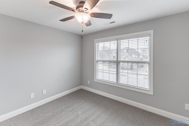 carpeted spare room featuring ceiling fan