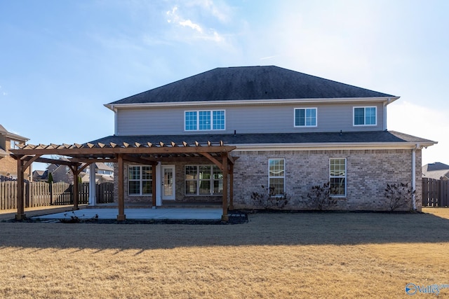 rear view of property with a pergola, a patio area, and a lawn