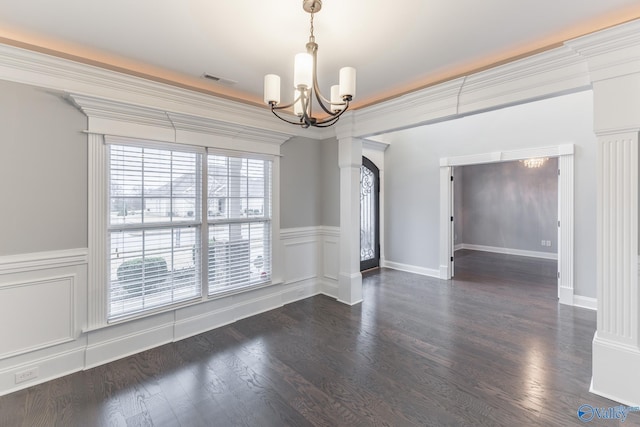 spare room with dark hardwood / wood-style flooring, ornamental molding, and a notable chandelier