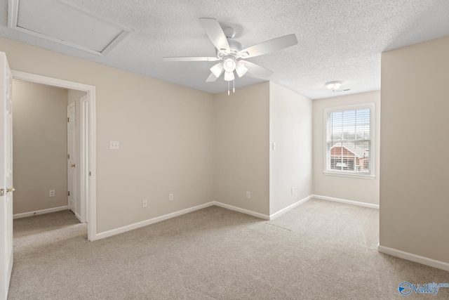 spare room with carpet flooring, a textured ceiling, baseboards, and a ceiling fan