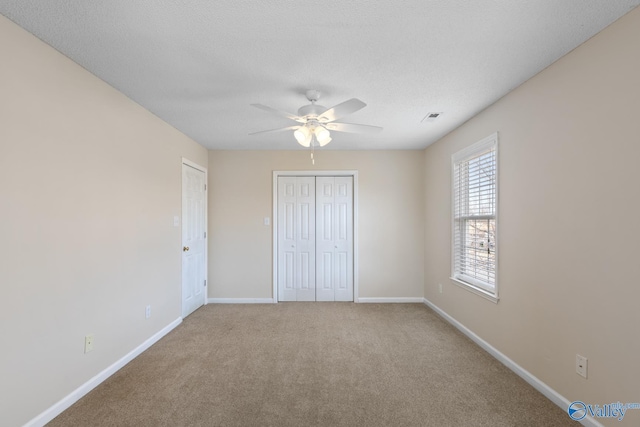 unfurnished bedroom with visible vents, baseboards, a textured ceiling, and carpet flooring