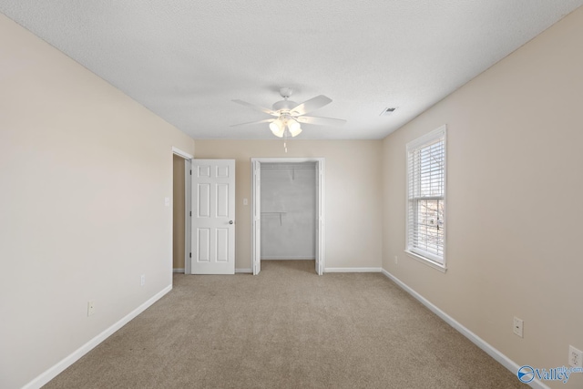 unfurnished bedroom with carpet flooring, visible vents, baseboards, and a closet