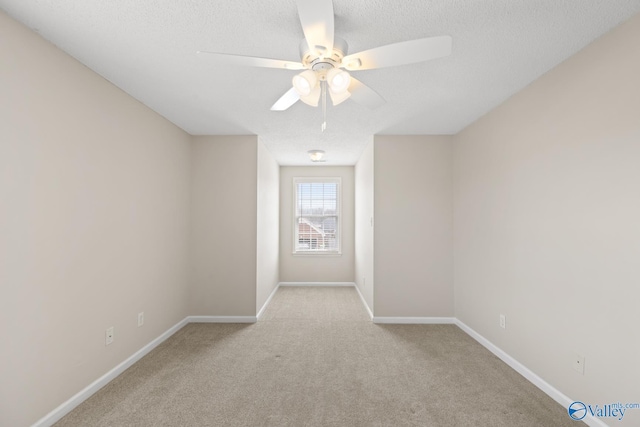 spare room with baseboards, a textured ceiling, carpet floors, and a ceiling fan