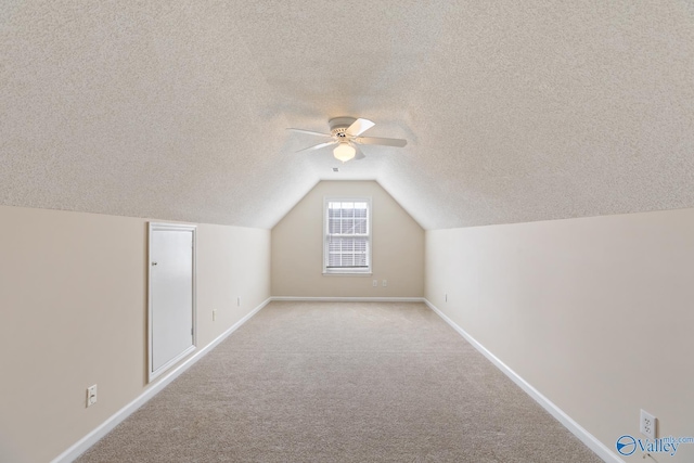 bonus room featuring vaulted ceiling, baseboards, carpet floors, and a textured ceiling