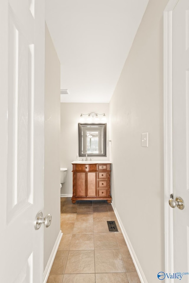 bathroom with tile patterned floors, visible vents, toilet, and vanity