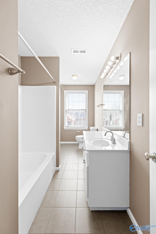 full bath featuring vanity, tile patterned floors, visible vents, and a textured ceiling