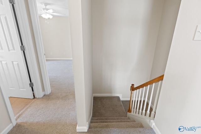 staircase with baseboards, carpet floors, and a ceiling fan